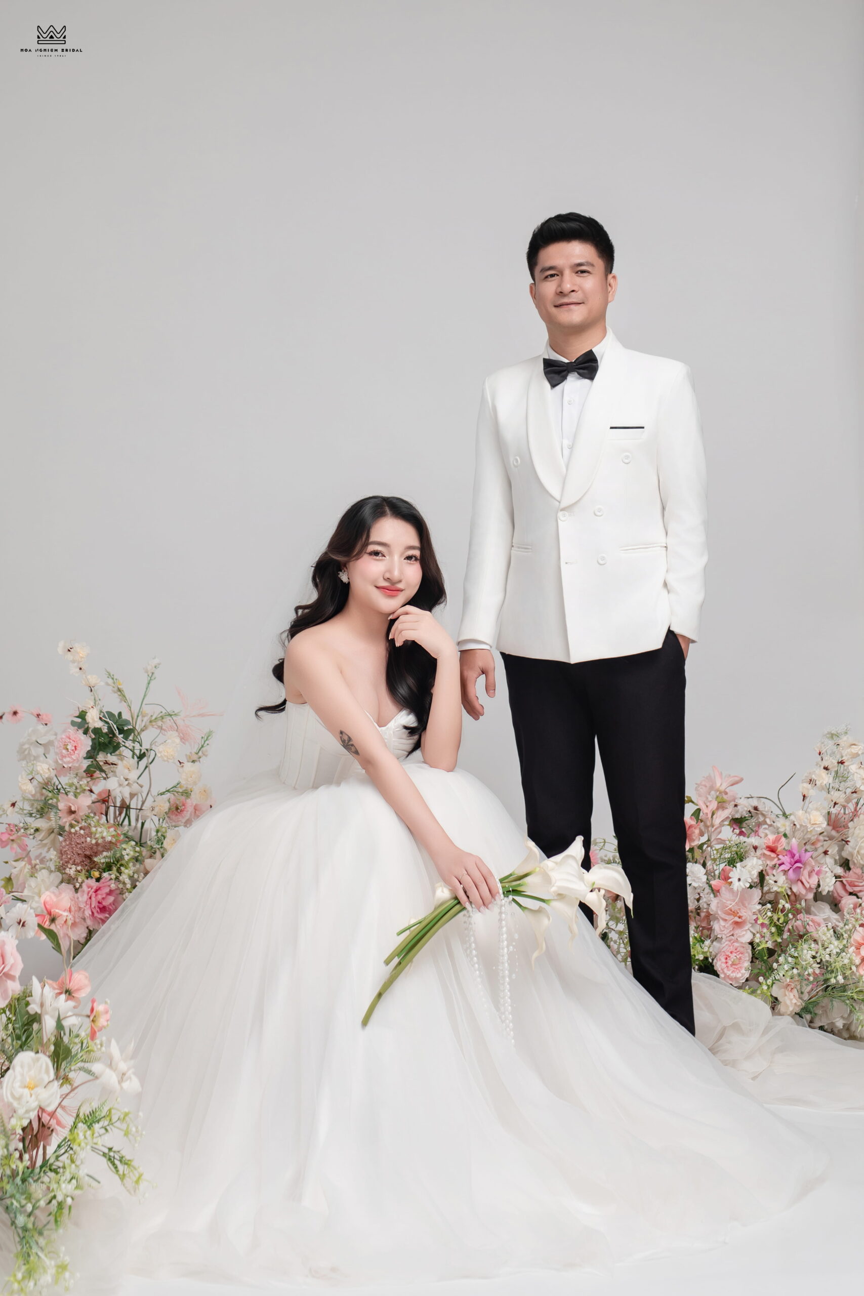 Ảnh cưới studio Thanh Long Nguyên Đồng với background hoa pastel nhẹ nhàng tại Huế