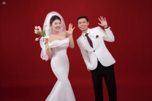 Chụp ảnh cưới studio phông nền đỏ cô dâu chú rể tạo dáng vui nhộn tại Huế