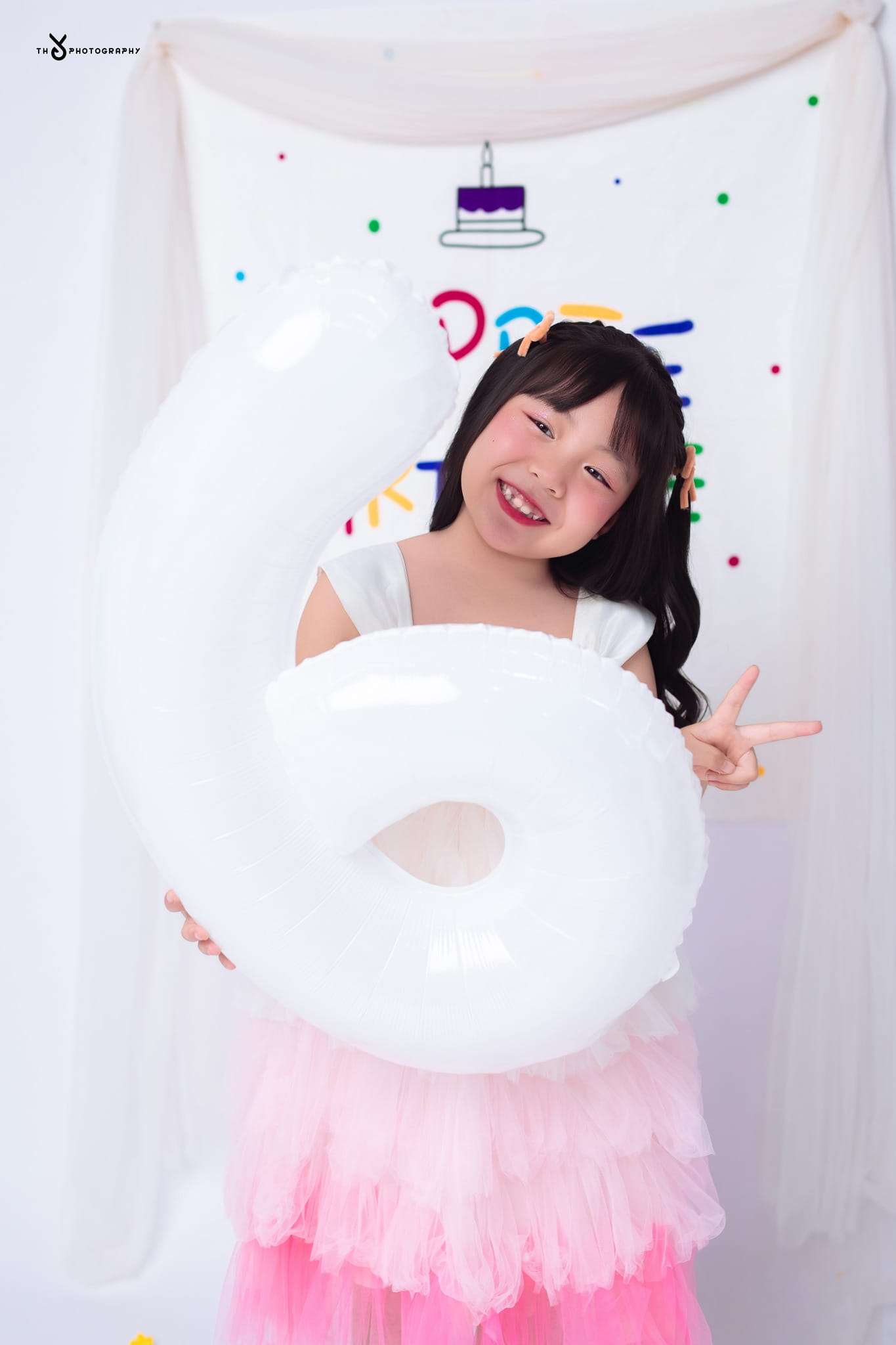 Chụp ảnh sinh nhật ở Huế với concept sinh nhật cho bé sử dụng bóng số, giúp bé thể hiện biểu cảm tự nhiên và vui tươi trong không gian studio chuyên nghiệp.