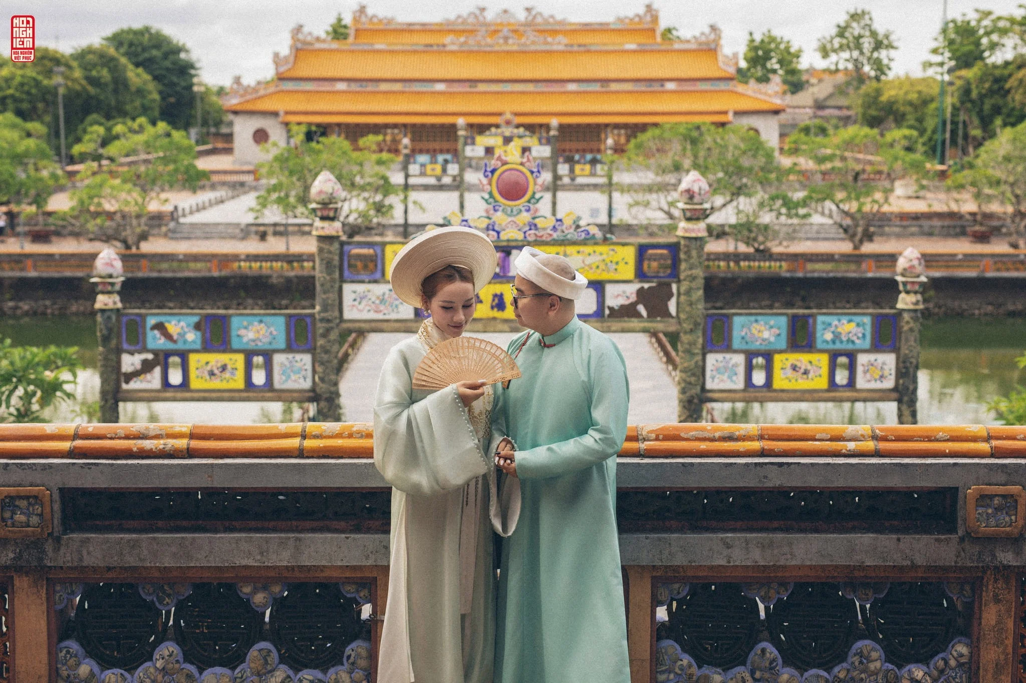 International tourists enjoying Vietnamese traditional costume rental and photography at Hue Imperial heritage sites with scenic palace and garden backgrounds.